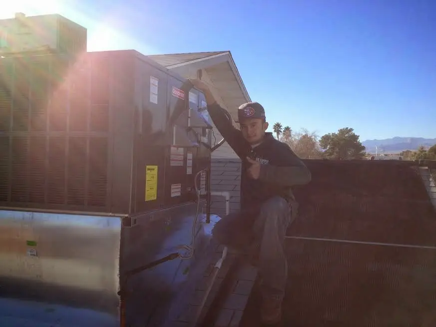 HVAC technician performing HVAC Inspection on a rooftop unit in Tiffin